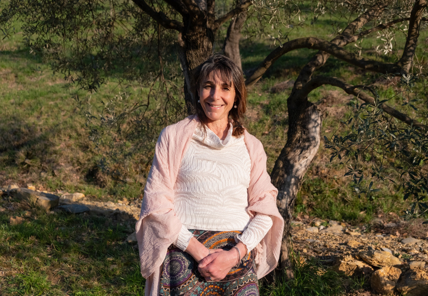 Donna sorridente in un uliveto ligure, contesto naturale dell'azienda agricola Virtus Mushroom