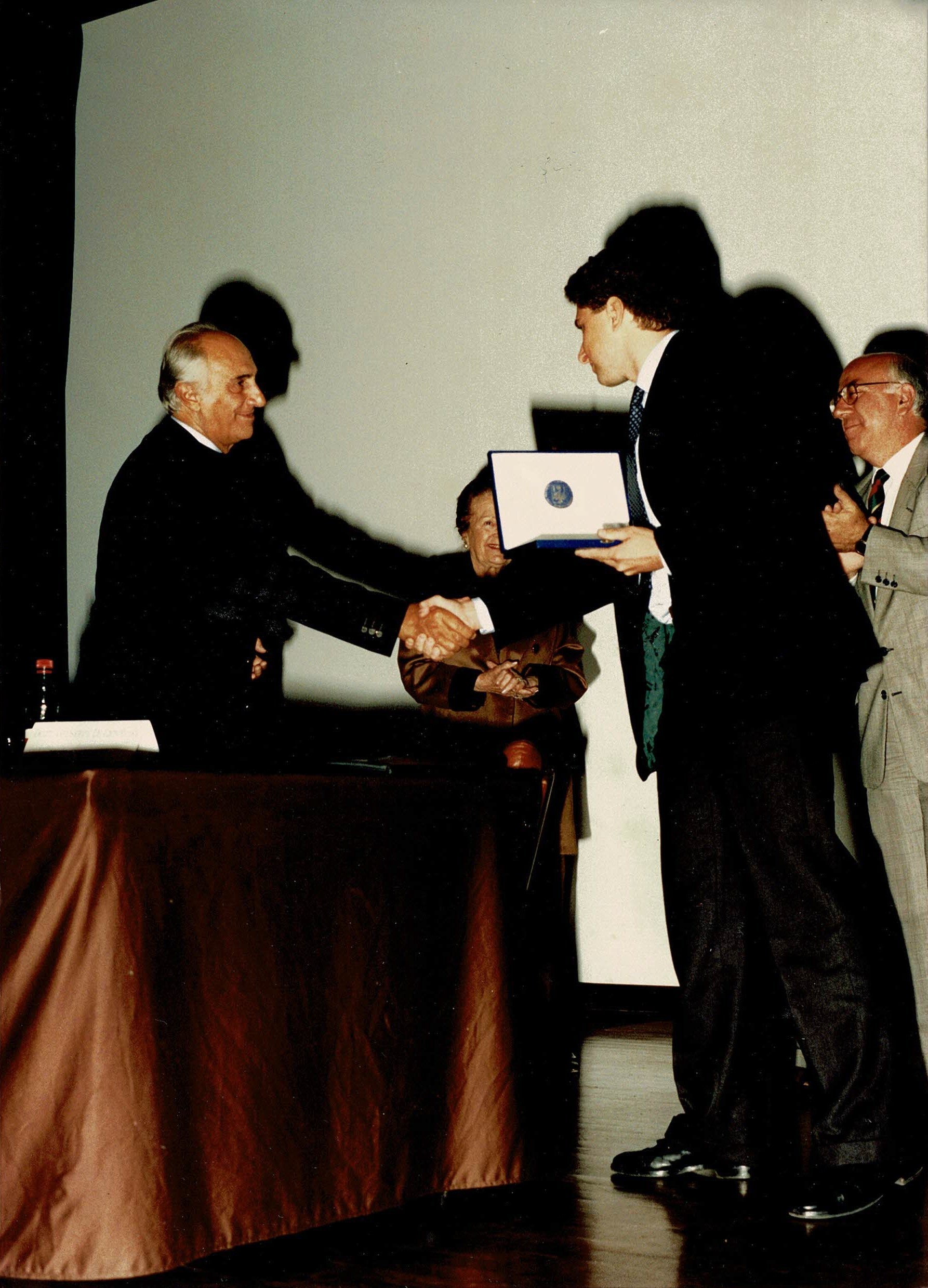 Cerimonia di premiazione formale con consegna di una targa durante un evento ufficiale